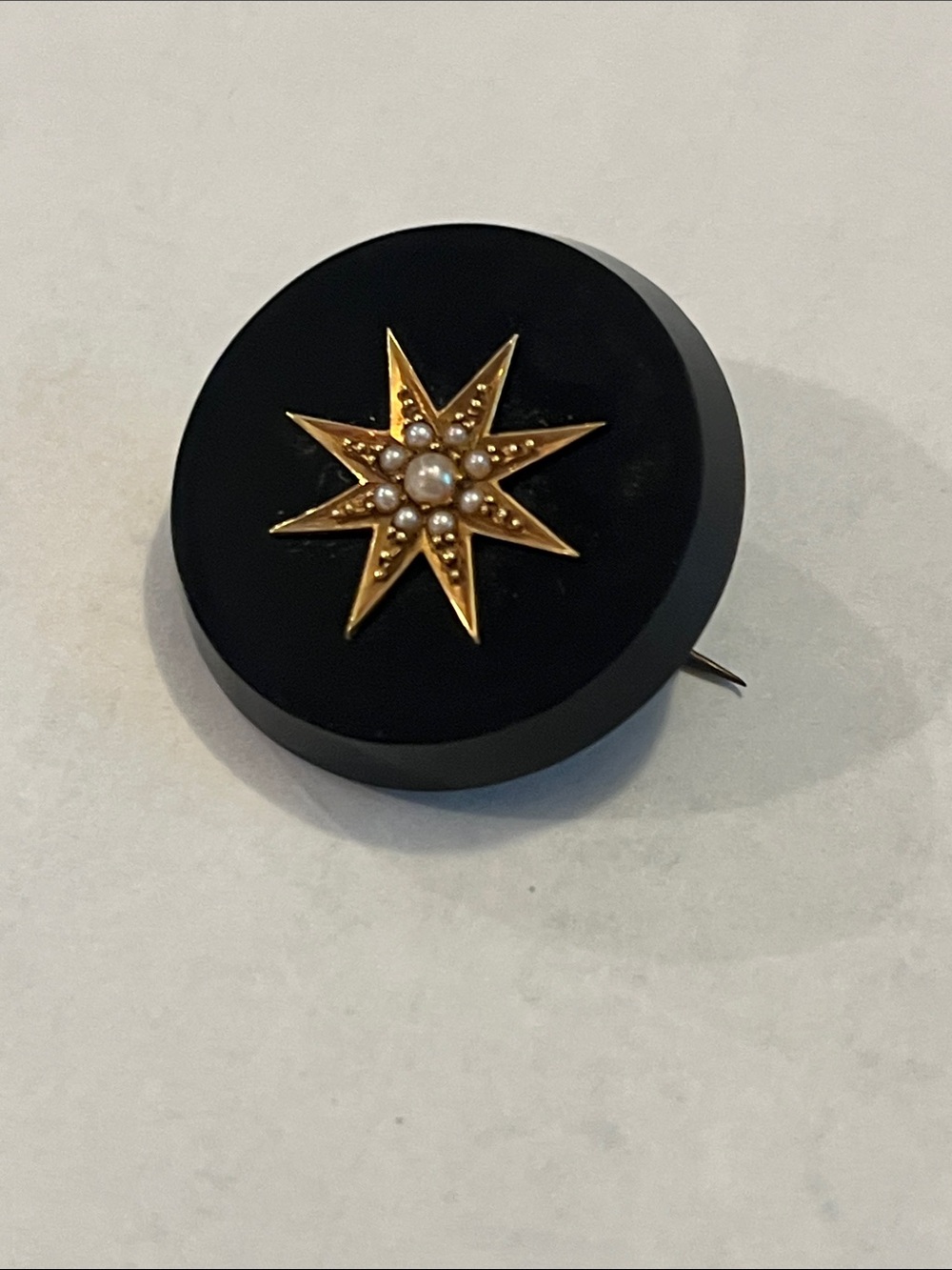 Antique (circa 1890s) black enamel brooch with seed pearls and C clasp.